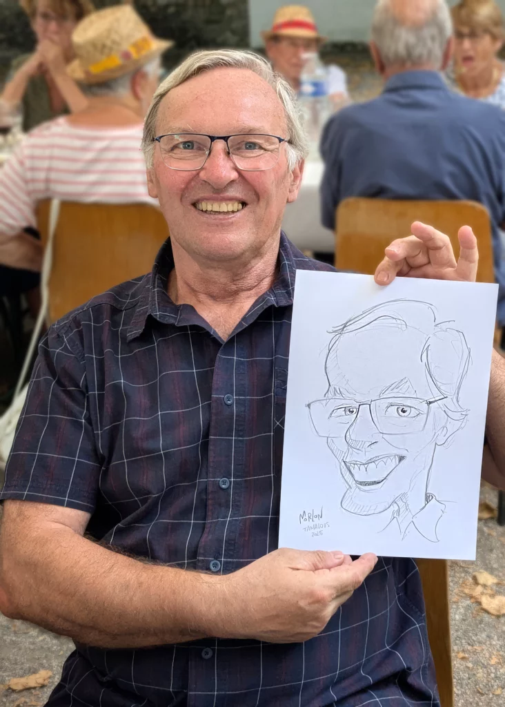 Homme présentant sa caricature réalisée en extérieur