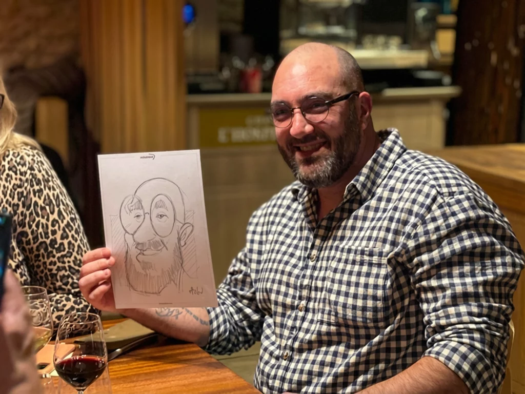 Invité souriant tenant sa caricature dessinée en soirée