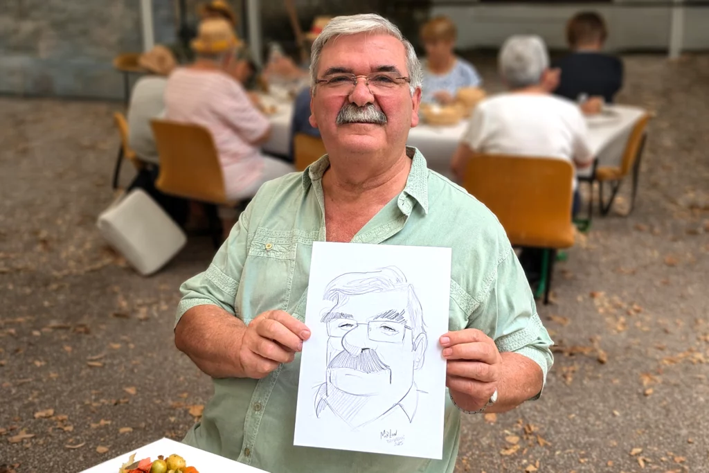 Homme moustachu posant avec sa caricature